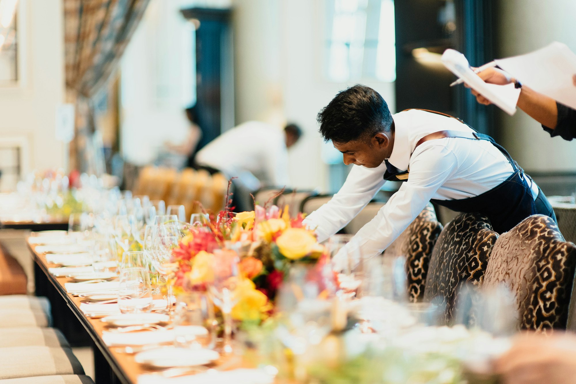 Front-of-house staff preparing an event table setting
